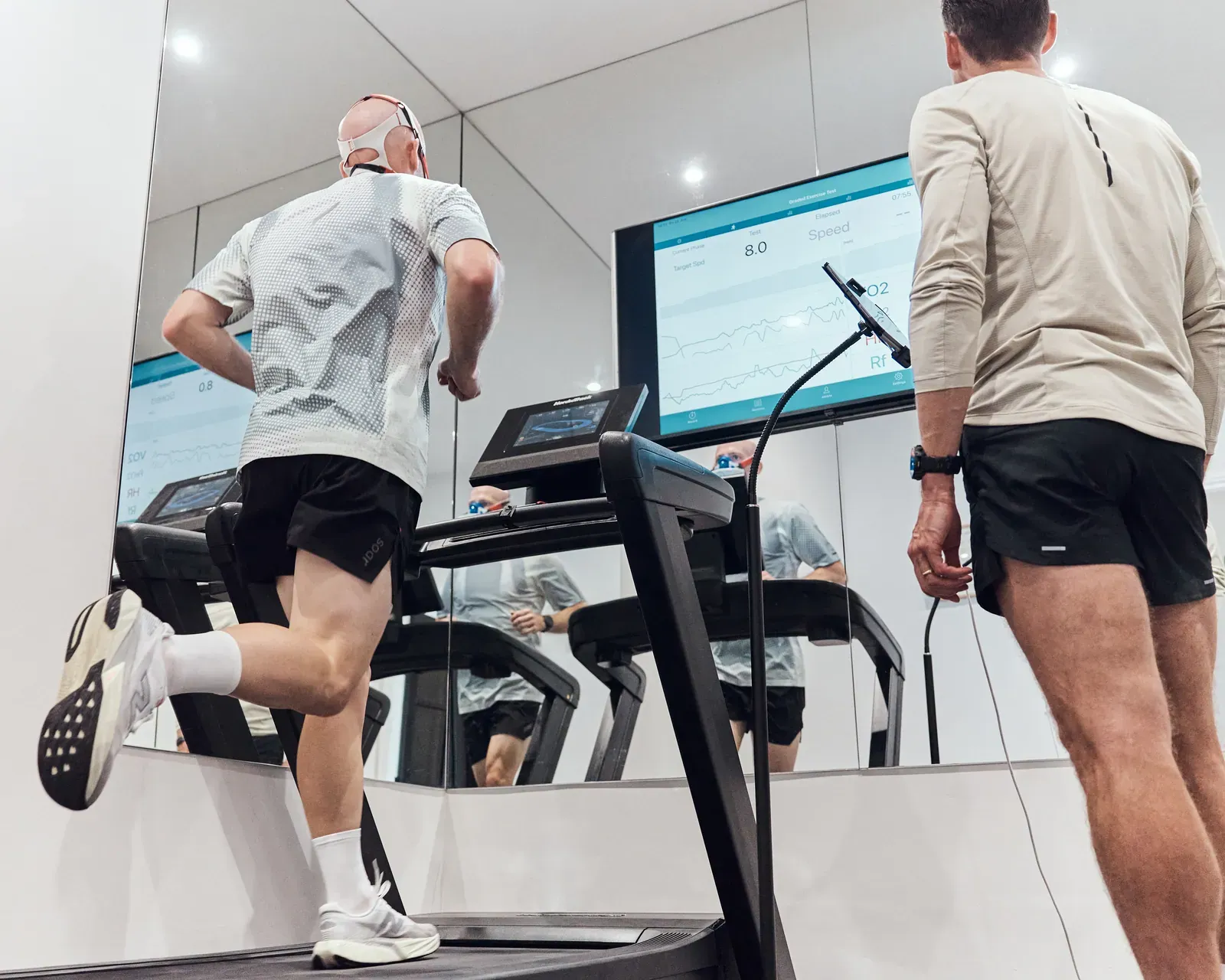 A runner on the treadmill during a VO₂ max test, with live metrics on screen